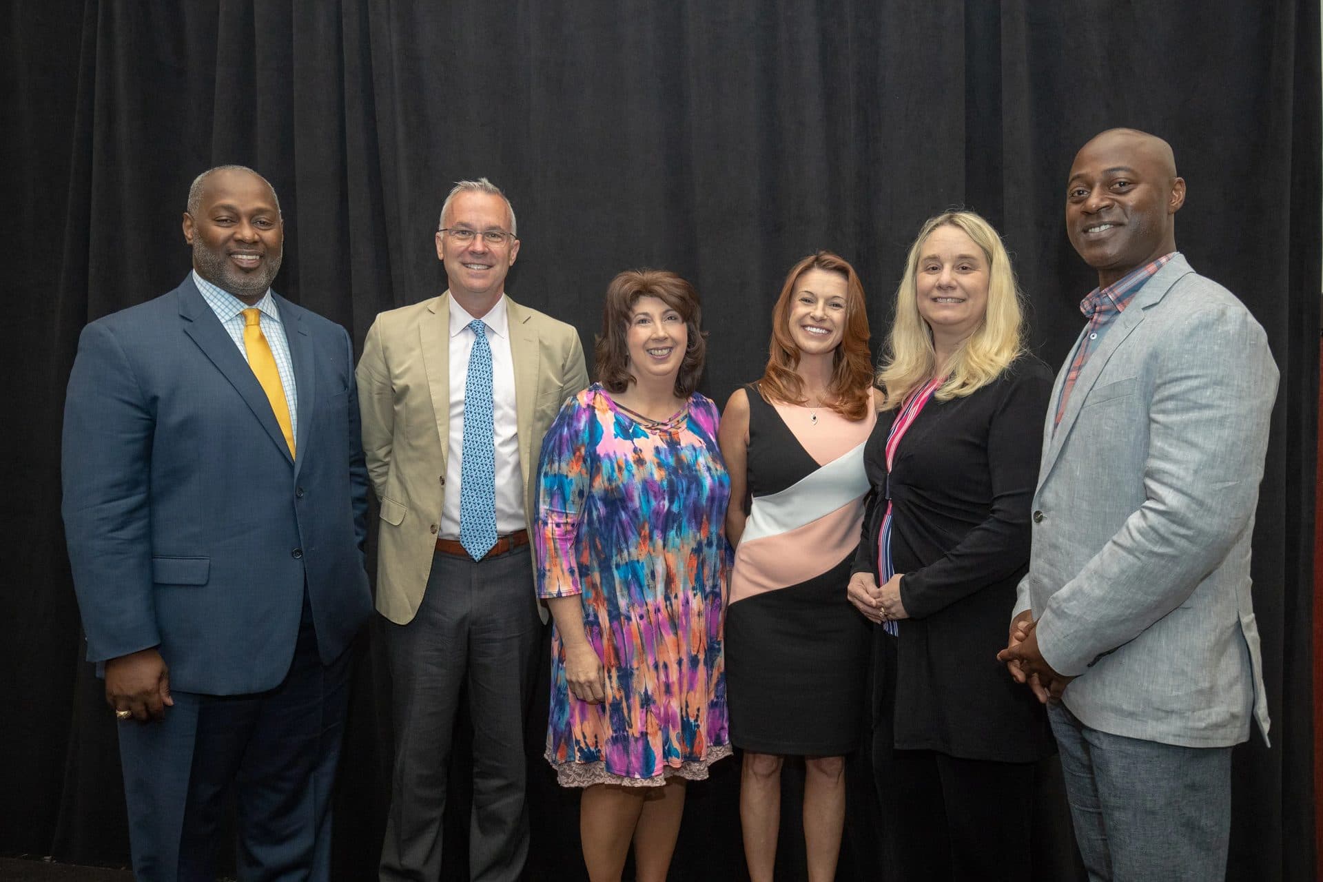 Partners posing together on stage at a Rural Summit event