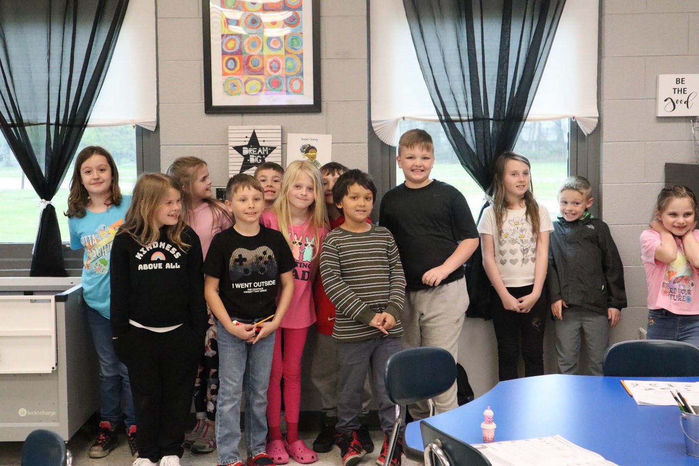 A group of elementary students pose for a photo in classroom